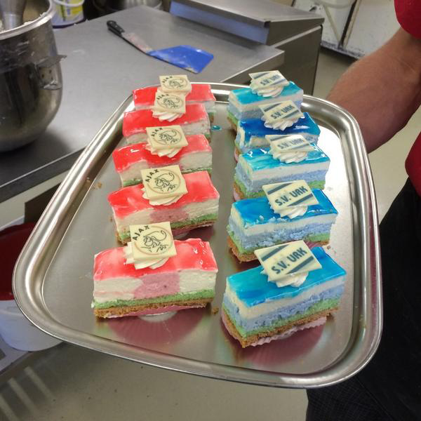 Klanten van Patisserie Jan de Bakker konden kiezen tussen blauw-witte SV Urk- of rood-witte Ajax-slagroomgebakjes, alle voorzien van een clublogo. Foto: @FlevolandSport / Twitter
