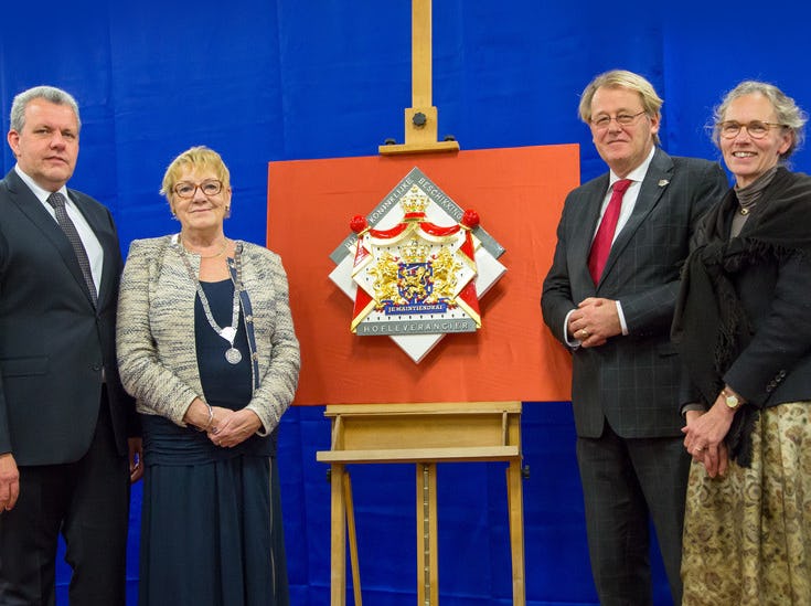 Gerrit Casteleijn, burgemeester Lennie Huizer van Krimpen aan den IJssel, Commissaris van de Koning drs. J. Smit van de provincie Zuid-Holland en Jeanette Casteleijn (v.l.n.r.) poseren bij het wapenschild. Foto: Bakkerij Casteleijn