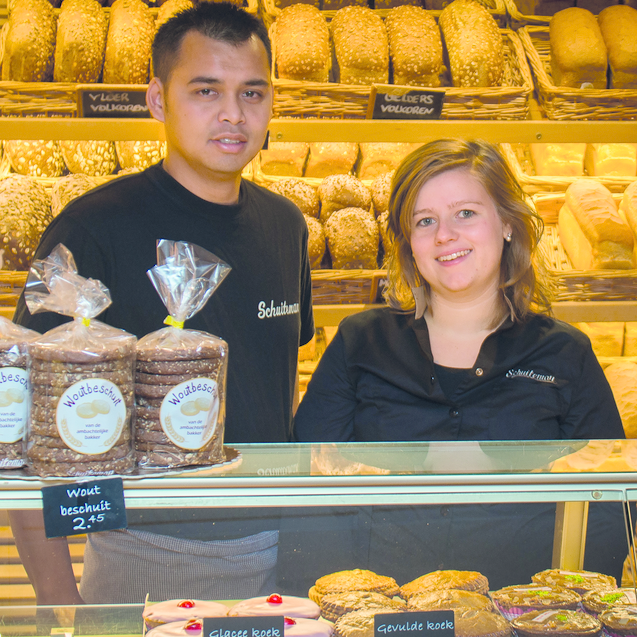 Sander van den Top  en zijn partner Martina: 'Als het erg druk is, ben ik de vliegende kiep, net zoals Peter Vermeulen, de eerdere eigenaar, was. Martina neemt de taken van zijn vrouw Arja over, zoals administratie en verkoop.' Foto: Brood- en Banketbakkerij Schuiteman