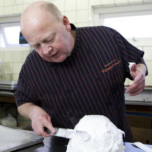 Marco Teunissen bereidt een profiteroltaart, die net als de appelslof erg in de smaak valt. Foto: Jan Willem Schouten