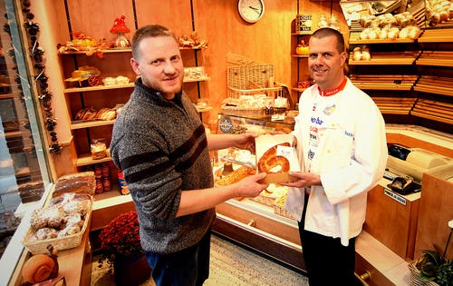 Erik Blom (l.) van Brood- en Banketbakkerij J. Blom in Zwammerdam overhandigt een banketcijfer 6 aan Paul Renirie van de Stichting Alphen d'HuZes. Foto: Stichting Alphen d'HuZes