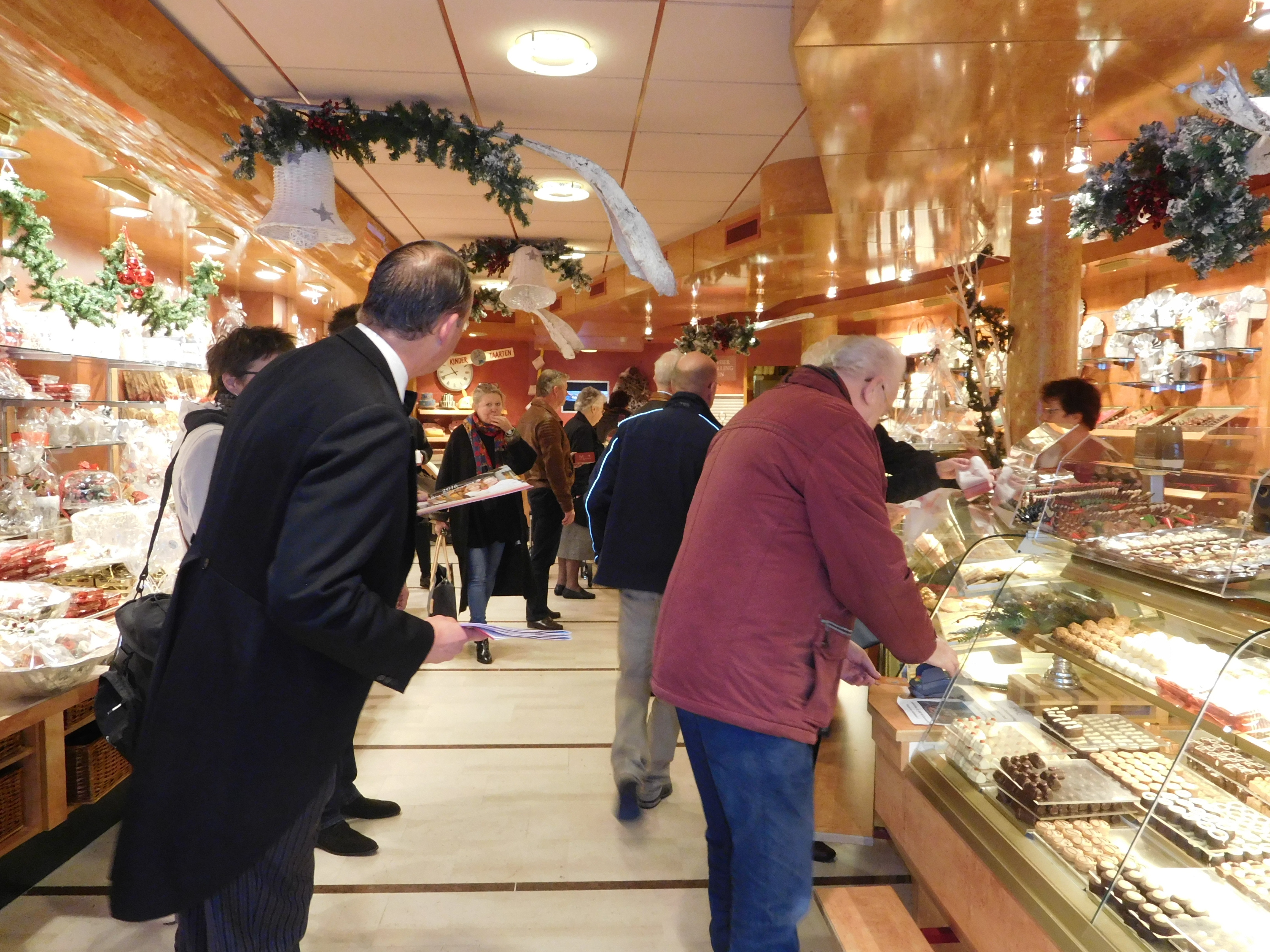 Klanten van Banketbakkerij Mekking ontvangen van Alphons de butler de kalender.