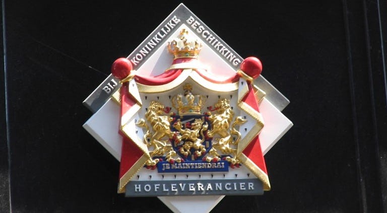 Het schild dat hoort bij het predicaat Hofleverancier.
Foto: Wikipedia