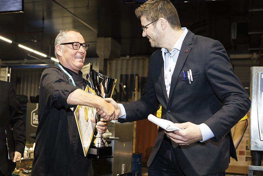 Bas Wigant (links) ontvangt zijn prijs uit handen van juryvoorzitter Dennis van Asselt.