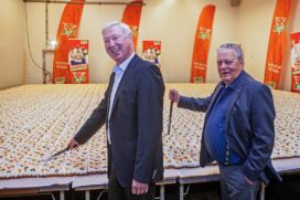 Anton Smit en Theo Poiesz, oud-directeuren van supermarktketen Poiesz, snijden de taart aan. (foto: Poiesz)