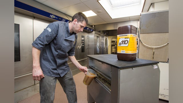 Het gebruik van andere olie verbetert de werkinig van de invetmachine (plaatpoetsmachine) en de afweegmachine. Foto: Medewerker Jeroen Gesell (37) voegt olie Trennaktiv B110 toe aan de invetmachine