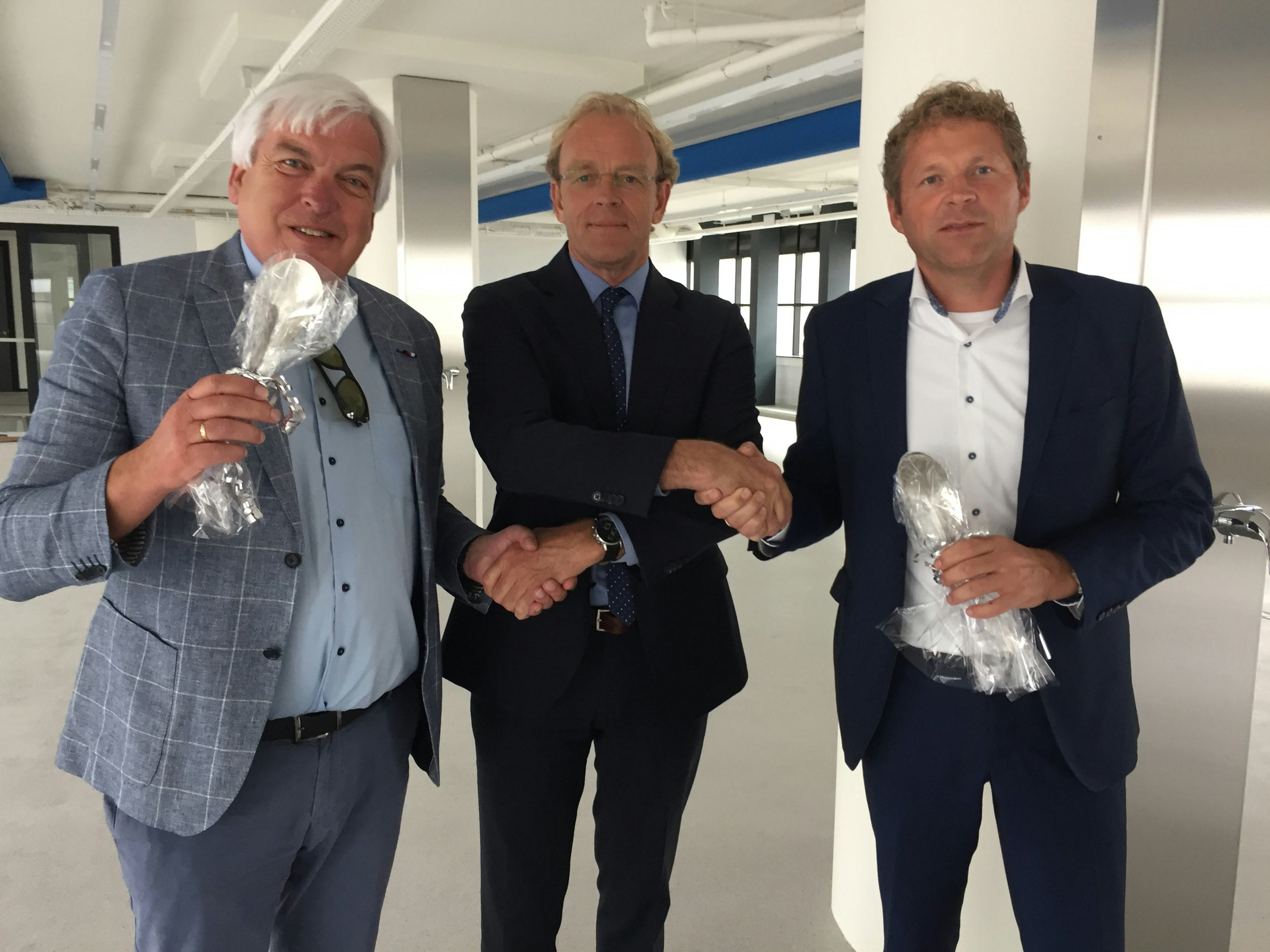 FIA-bestuurders Gert Kant (links) en Alfred Bruin (rechts) schudden Klaas Huizenga (midden) interim-directeur Rijn IJssel Vakschool Wageningen) de hand, om de overname van het IJscentrum door de Stichting Food Innovation Academy (FIA) te bekrachtigen. Huizenga overhandigde de FIA-bestuurders verder nog symbolisch een ijsspatel en wenst de FIA veel succes met de voortzetting van het IJscentrum.
