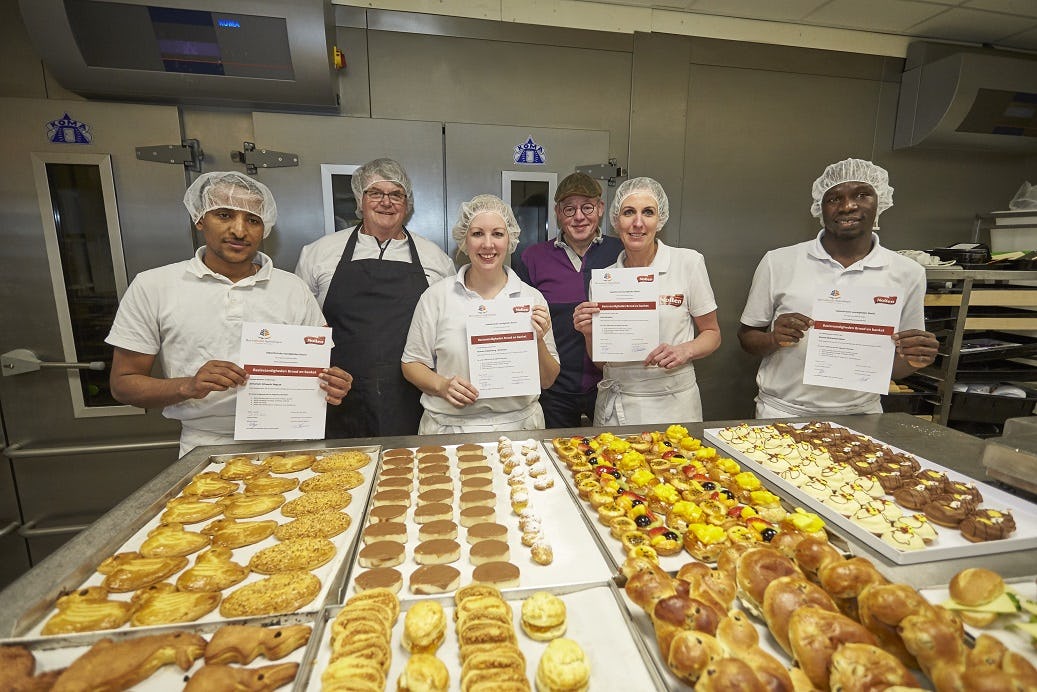 Bakkerij Nollen in Lochem reikt de certificaten uit aan de eerste cursisten van de eigen bakkersopleiding. Van links naar rechts:: Zemariam Afewerki, Bakker Richard Jansen, Tasmara  Krabbenbog, Hans Hulshof, Lisette  ten Breteler en Ahmed Adam. Foto's: Arjan Gotink