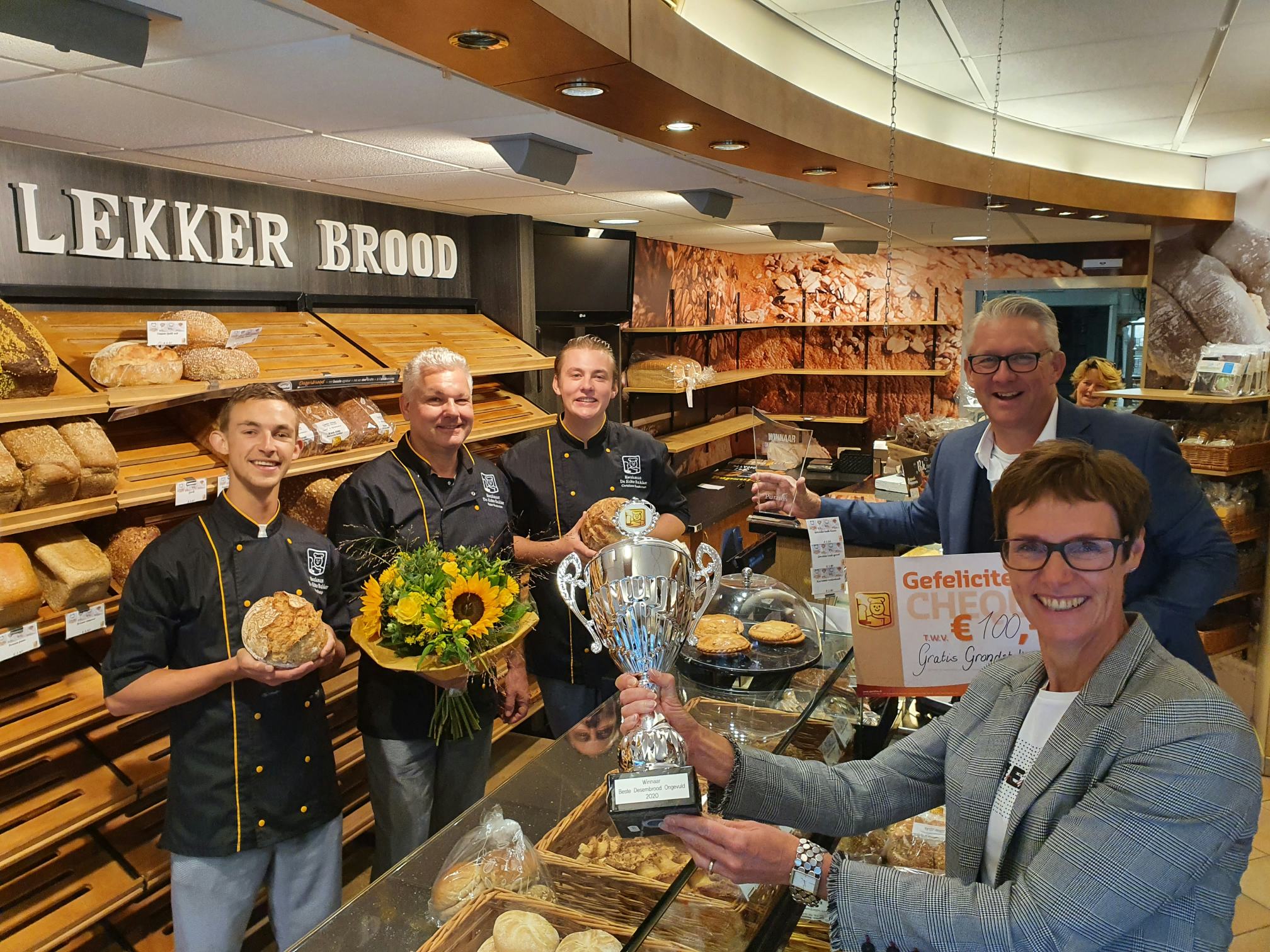 De uitreiking van de award 'desem ongevuld' bij Kwakman, De Echte Bakker uit Bussum. Vlnr: Joey Haage, Peter Kwakman, Christiaan Kwakman. Voor de toonbank: Bart van Gelder en Anita Elsjan.
Foto's: EB