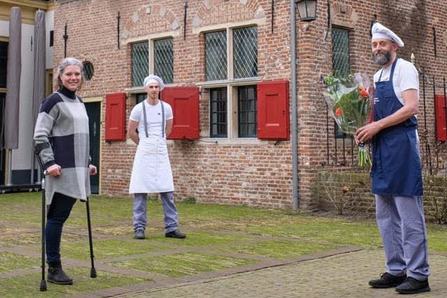 Museumdirecteur Fred Voskuil krijgt de bloemen die horen bij de ANWB-Publieksprijs 2021 van burgemeester Marleen Sanderse (l) van Hattem.