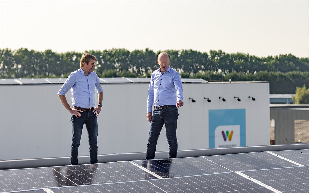Directieleden Krijno Davidse en Rob Jeras bekijken het zonnedak op het distributiecentrum van verpakkingsspecialist Weststrate.