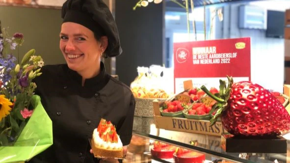 Winnaar Rosanne Buitenhuis is trots. Ze was niet aanwezig in Beesd; maar toont haar blijdschap bij bakkerij Oonk, waar ze werkzaam is.