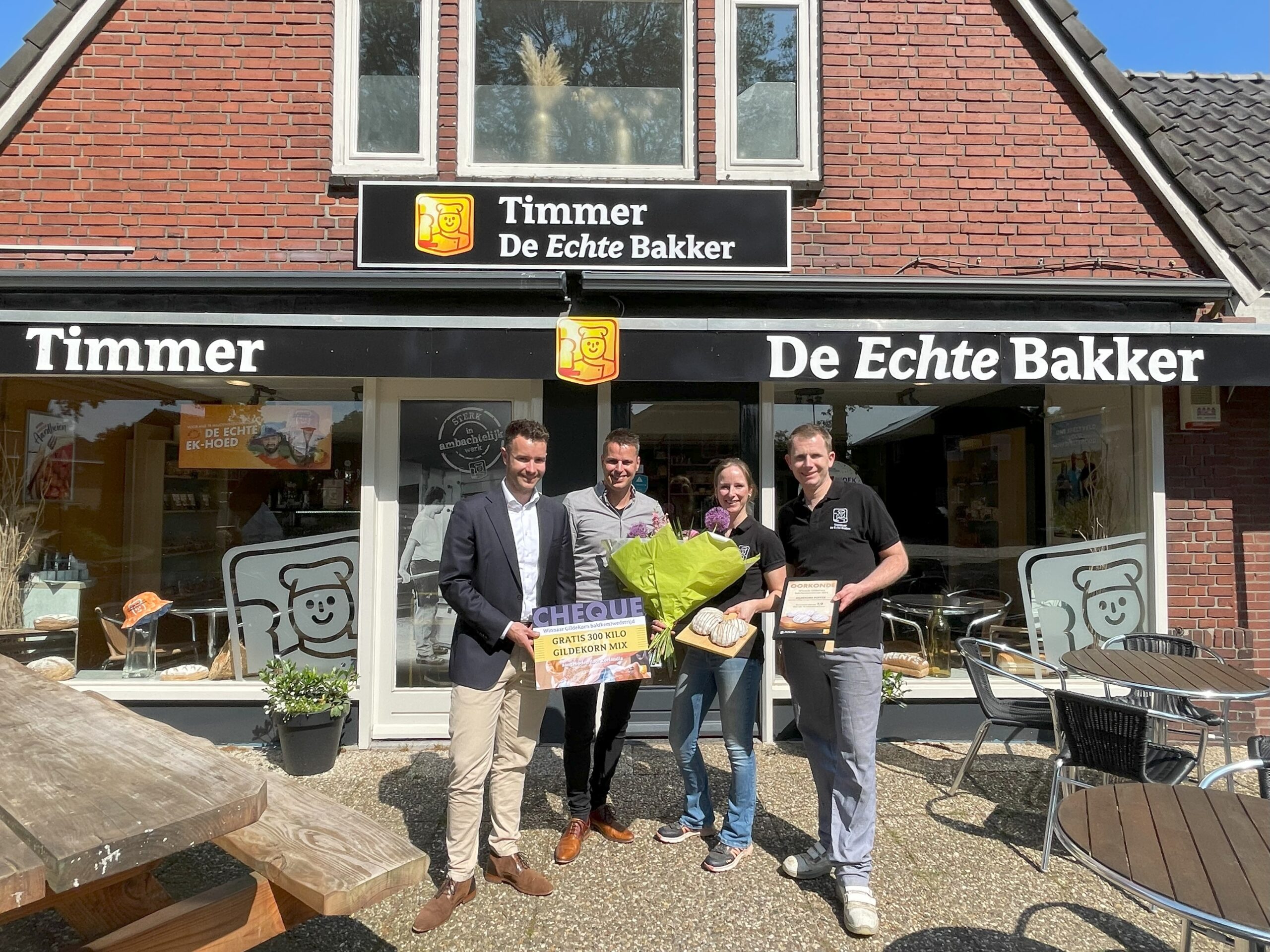 Ronald van Bokhorst (Echte Bakkersgilde) en Don Schavemaker (Zeelandia) overhandigden bloemen én een mooie cheque aan de winnende Echte Bakker Timmer.