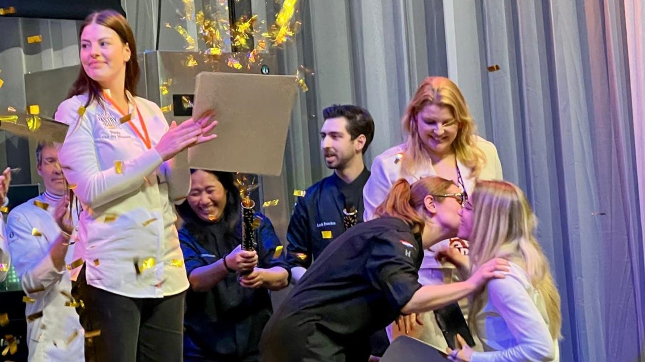 Serena van Breukelen (rechts) krijgt felicitatiezoenen van Noah Vlemmix, de winnares van 2024. Femke van der Muuren werd tweede en wacht tot haar winnende collega het erepodium betreedt. Foto: AMR