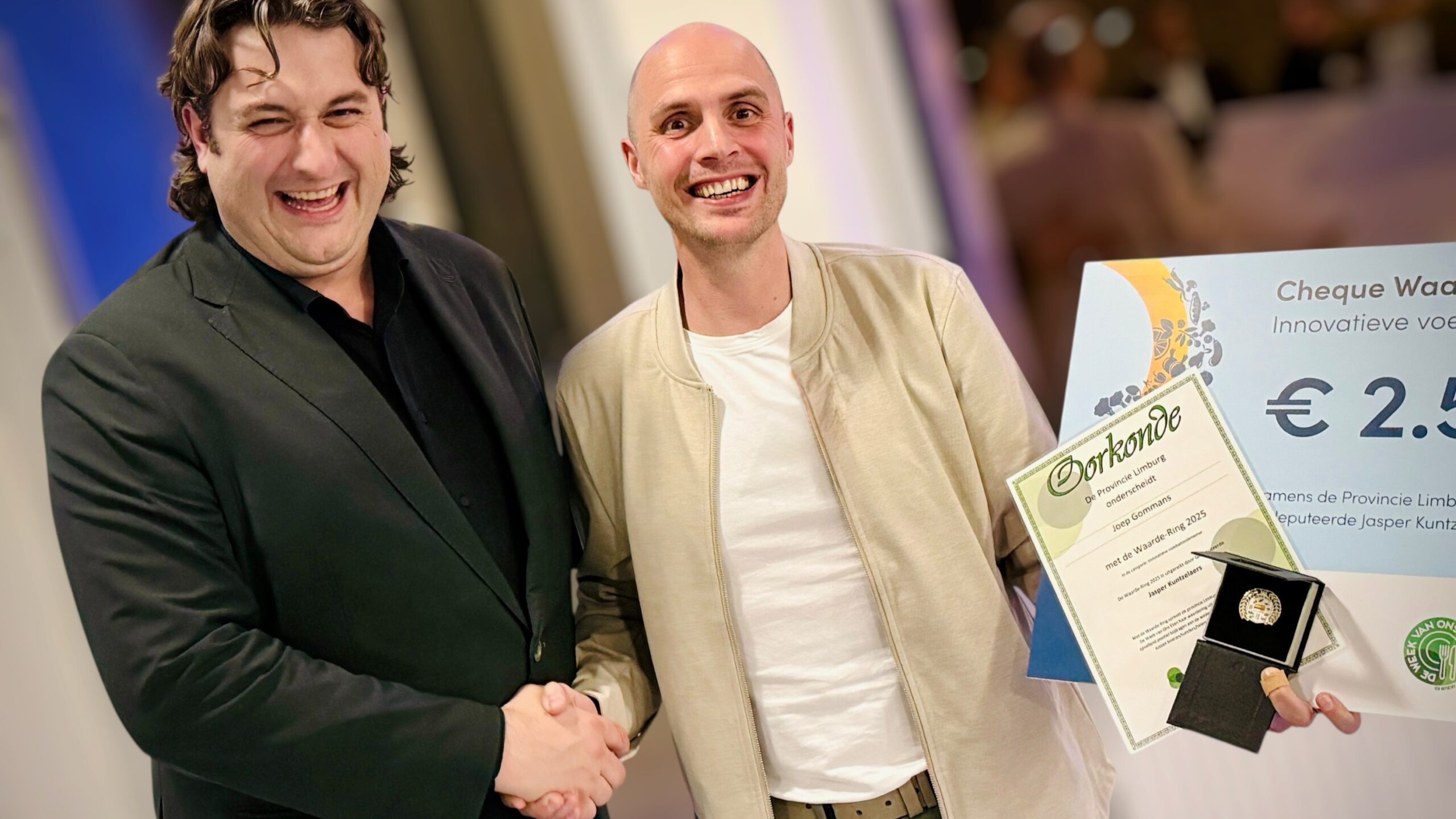 Joep Gommans ontvangt de waardering uit handen van Limburgs gedeputeerde Jasper Kuntzelaers. Foto: Gommans