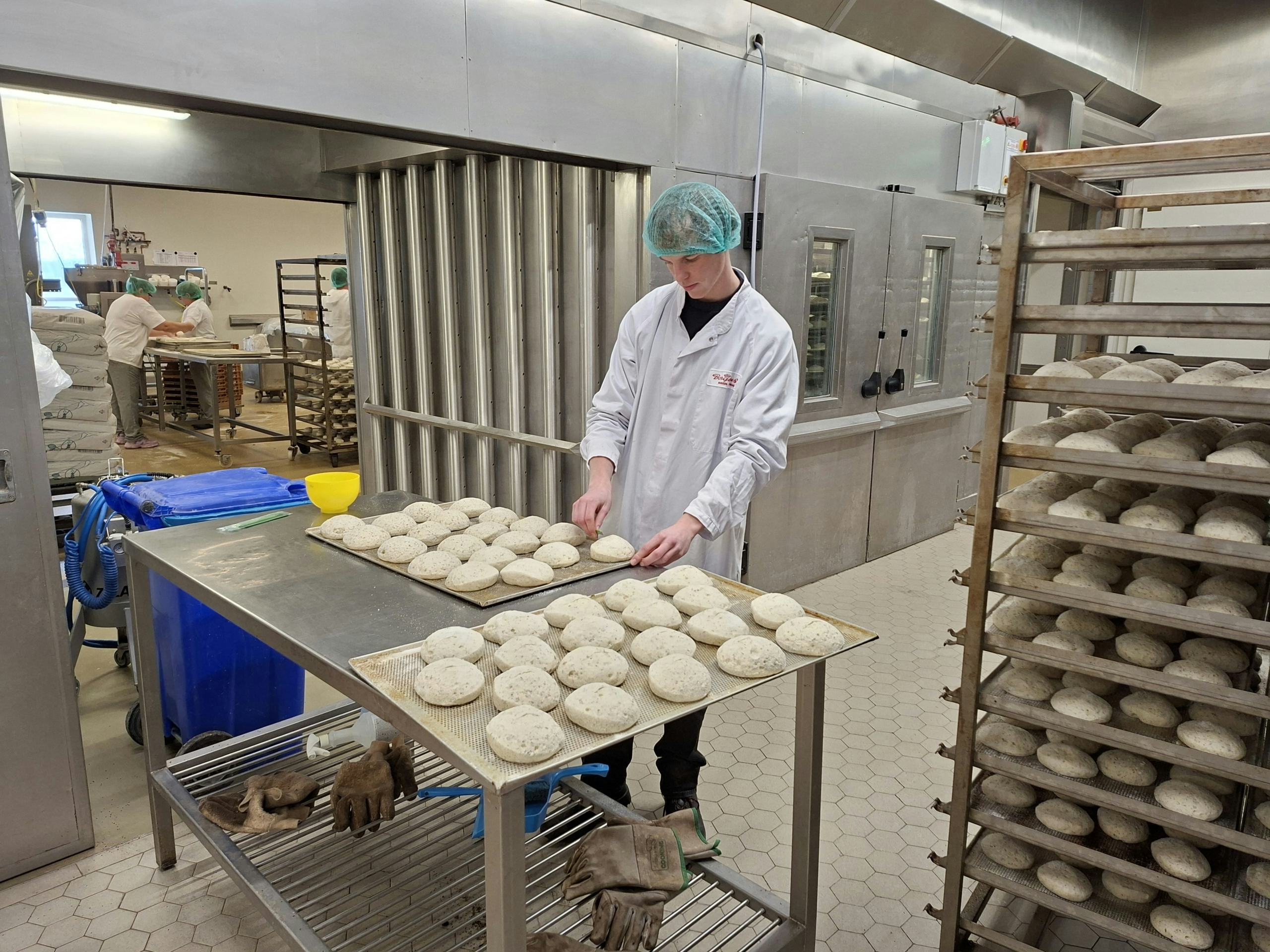 Sander Loman controleert de producten in de glutenvrije bakkerij van Borgesius. Hij werkt ook mee in de productie.