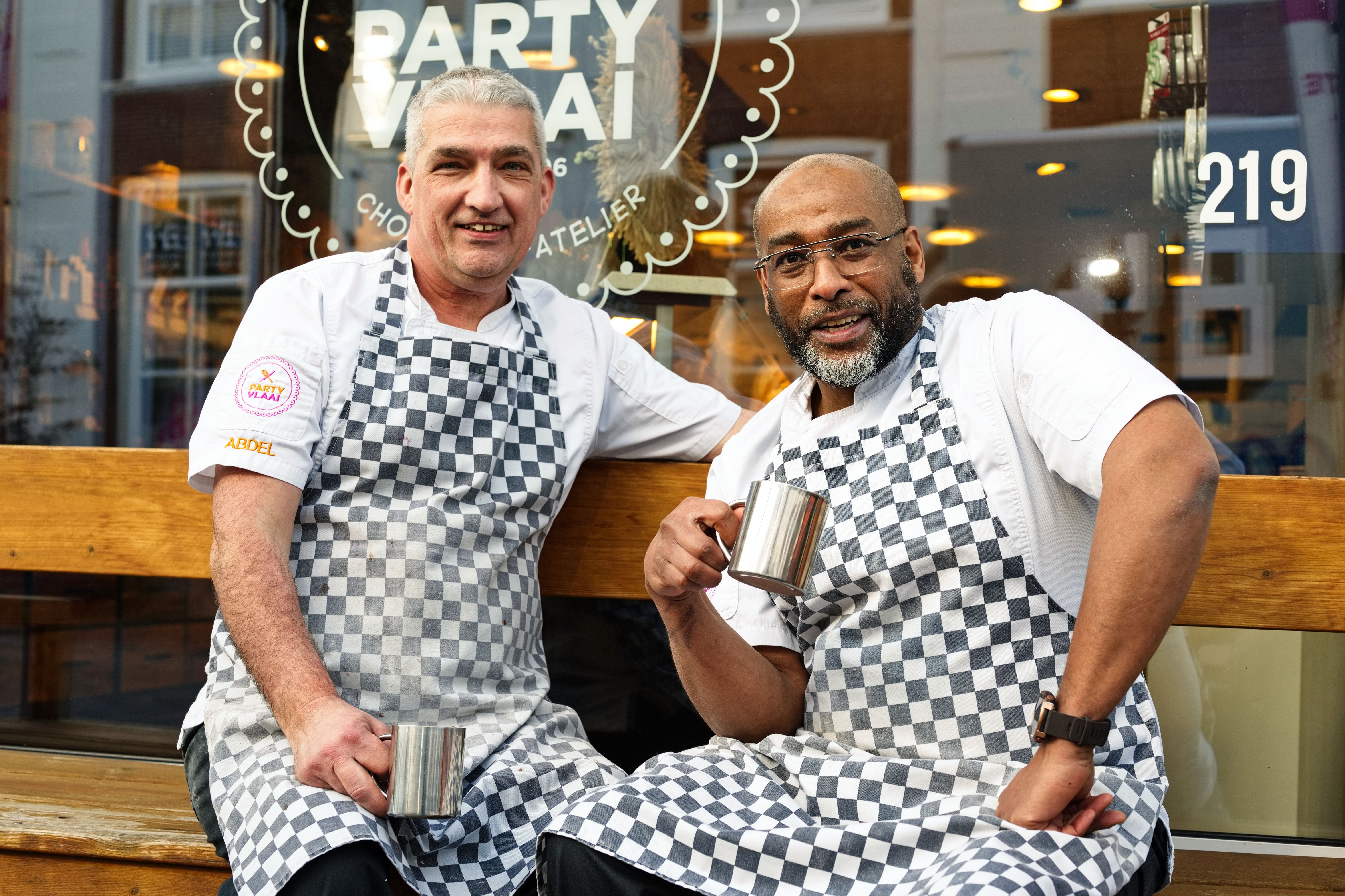 Henk Klein (links) en Abdel Razak Chraou buiten op bank voor een koffiepauze. 